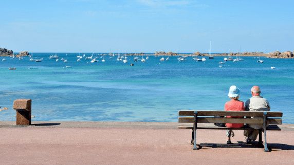 starzy ludzie siedzą na ławce nad wodą