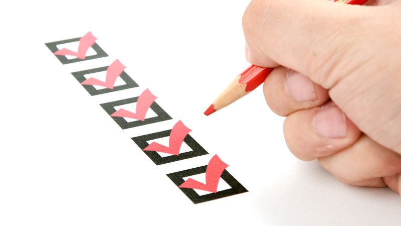 człowiek zaznacza checkboxy czerwoną kredką