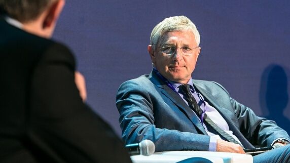 starszy człowiek siedzi w garniturze na krześle