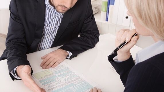 człowiek tłumaczy coś kobiecie nad dukumentami