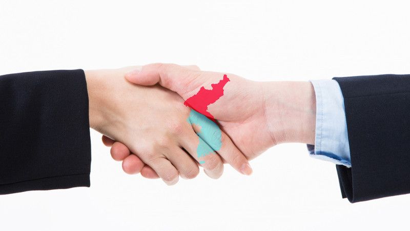 Uścisk dłoni i  kontur obu Korei