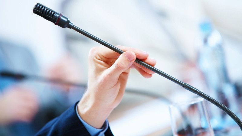 człowiek trzyma szyjkę od mikrofonu