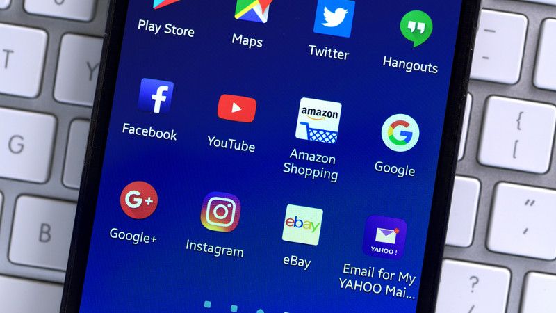 smartfon leży na klawiaturze z wyświetlonym pulpitem pełnym aplikacji